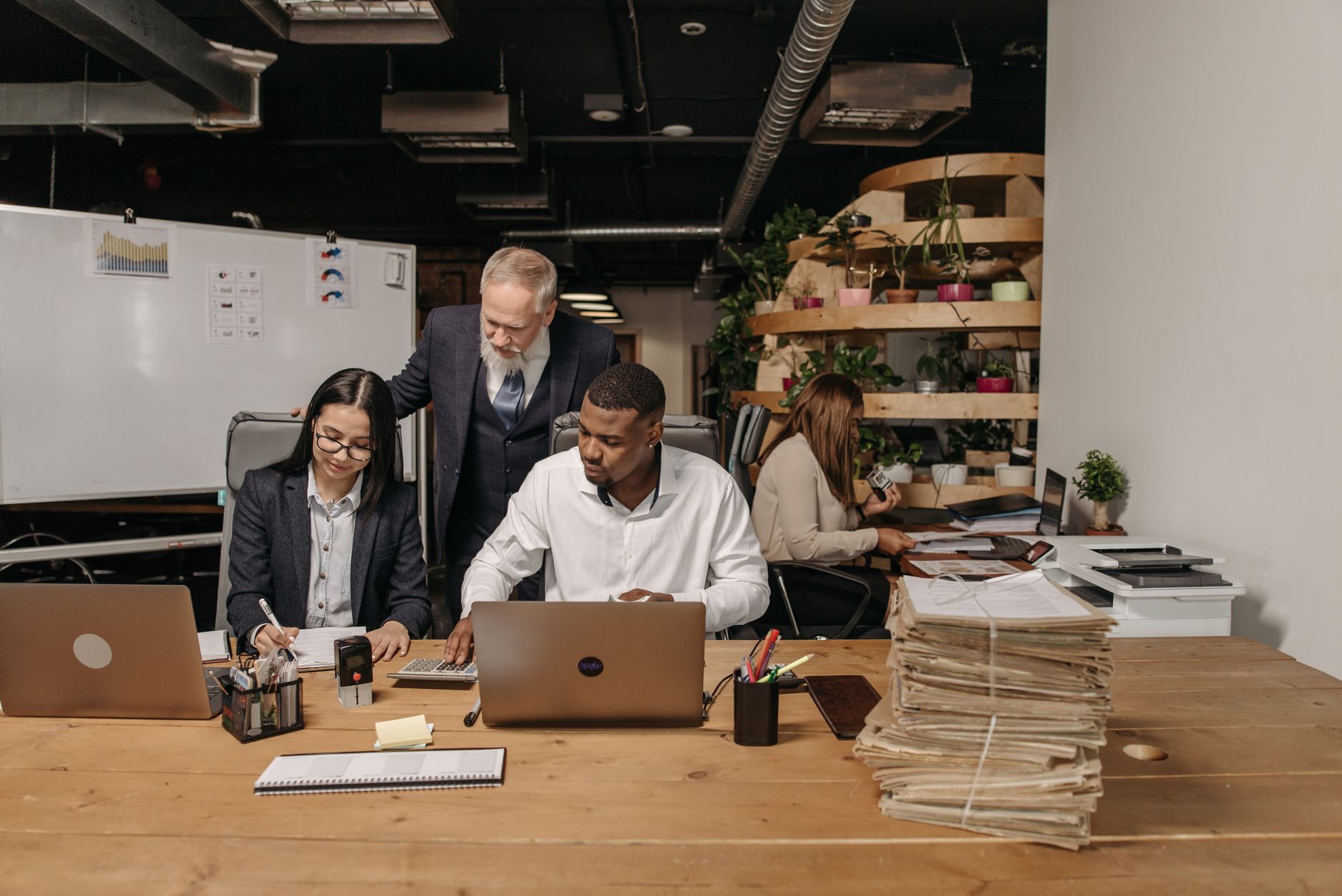 Redactieteam beoordeelt profielen achter laptops op kantoor