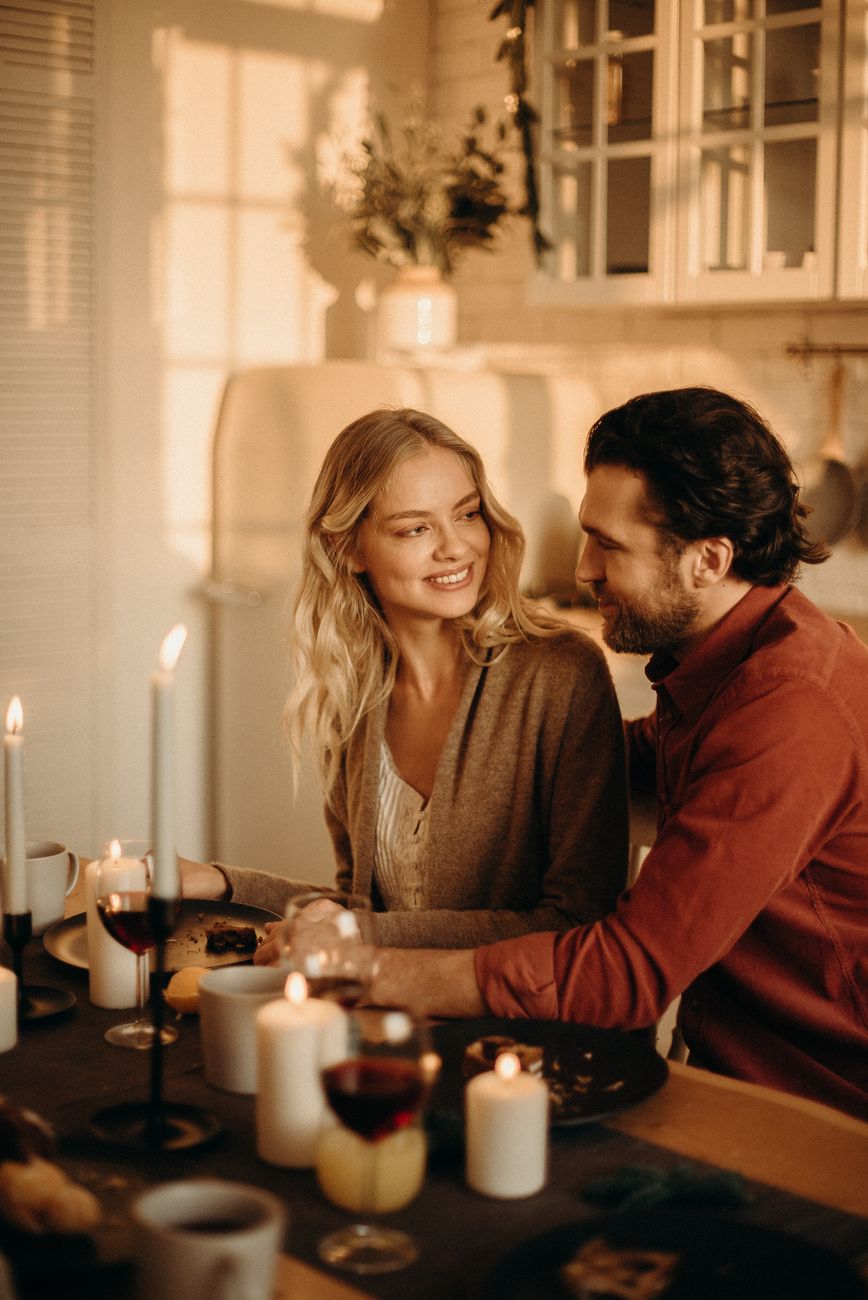 Lachend stel aan tafel bij kaarslicht tijdens een date