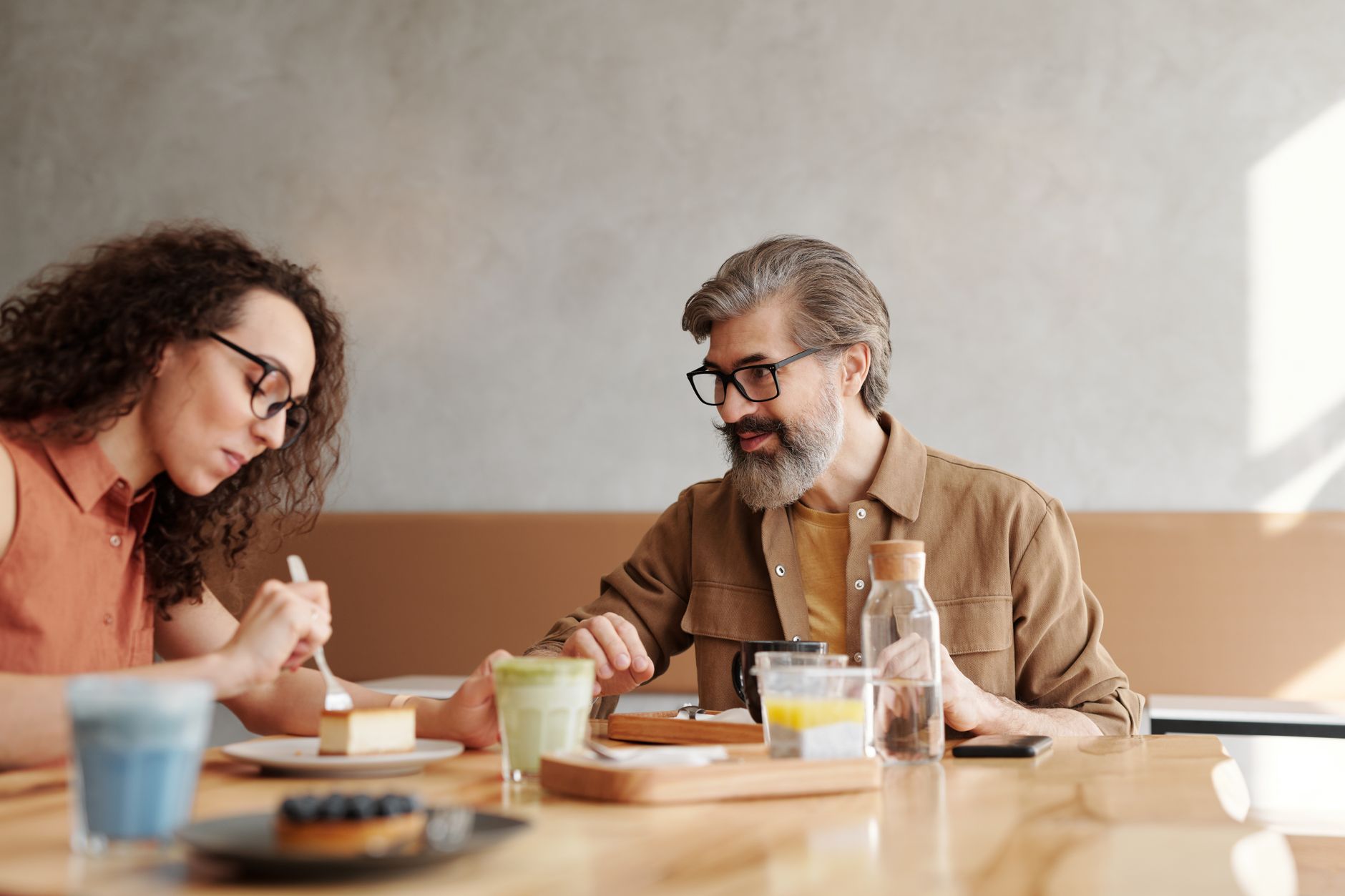 Twee mensen aan een cafetafel met koffie en gebak