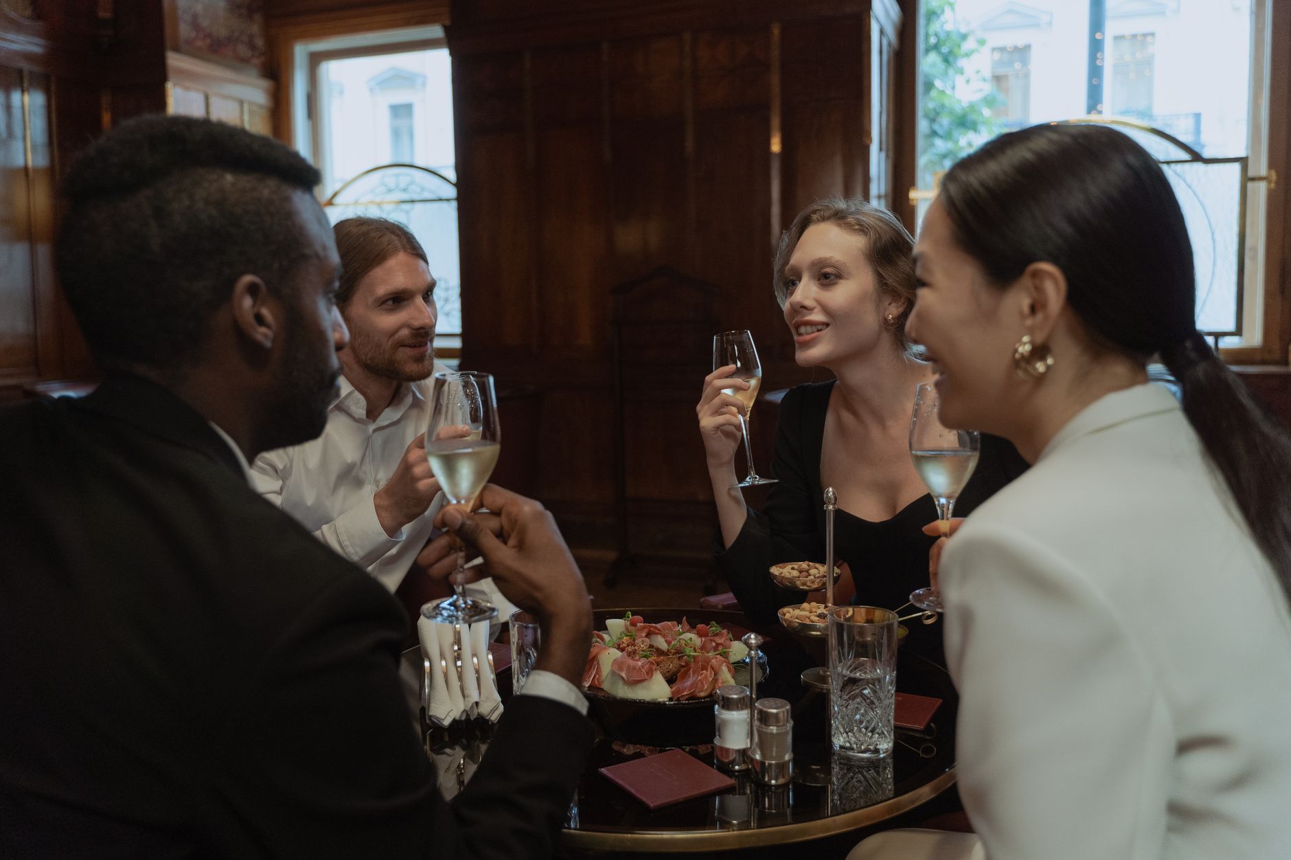 Groep mensen proost lachend met elkaar in een warm verlicht restaurant